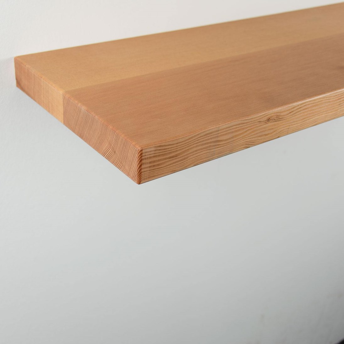 Zwevende oregon pine wandplank in de maat 1000x250x38mm, behandeld met lak.