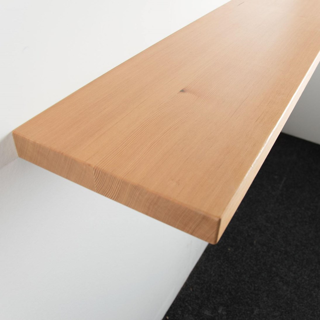 Zwevende oregon pine wandplank in de maat 1000x250x38mm, behandeld met lak.