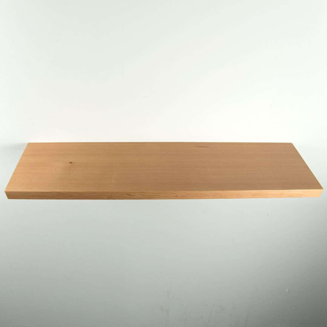 Zwevende oregon pine wandplank in de maat 1000x250x38mm, behandeld met lak.