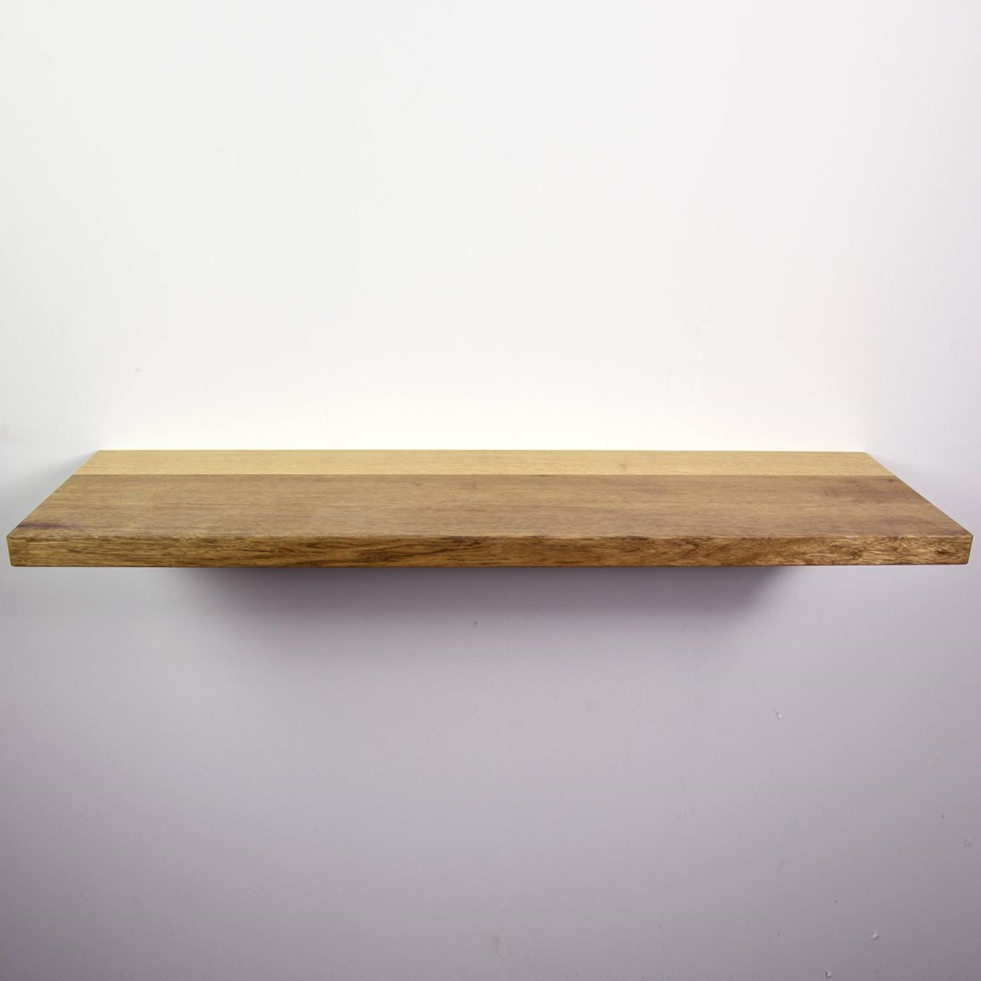Zwevende mansonia wandplank in de maat 1140x338x40mm, behandeld met lak.