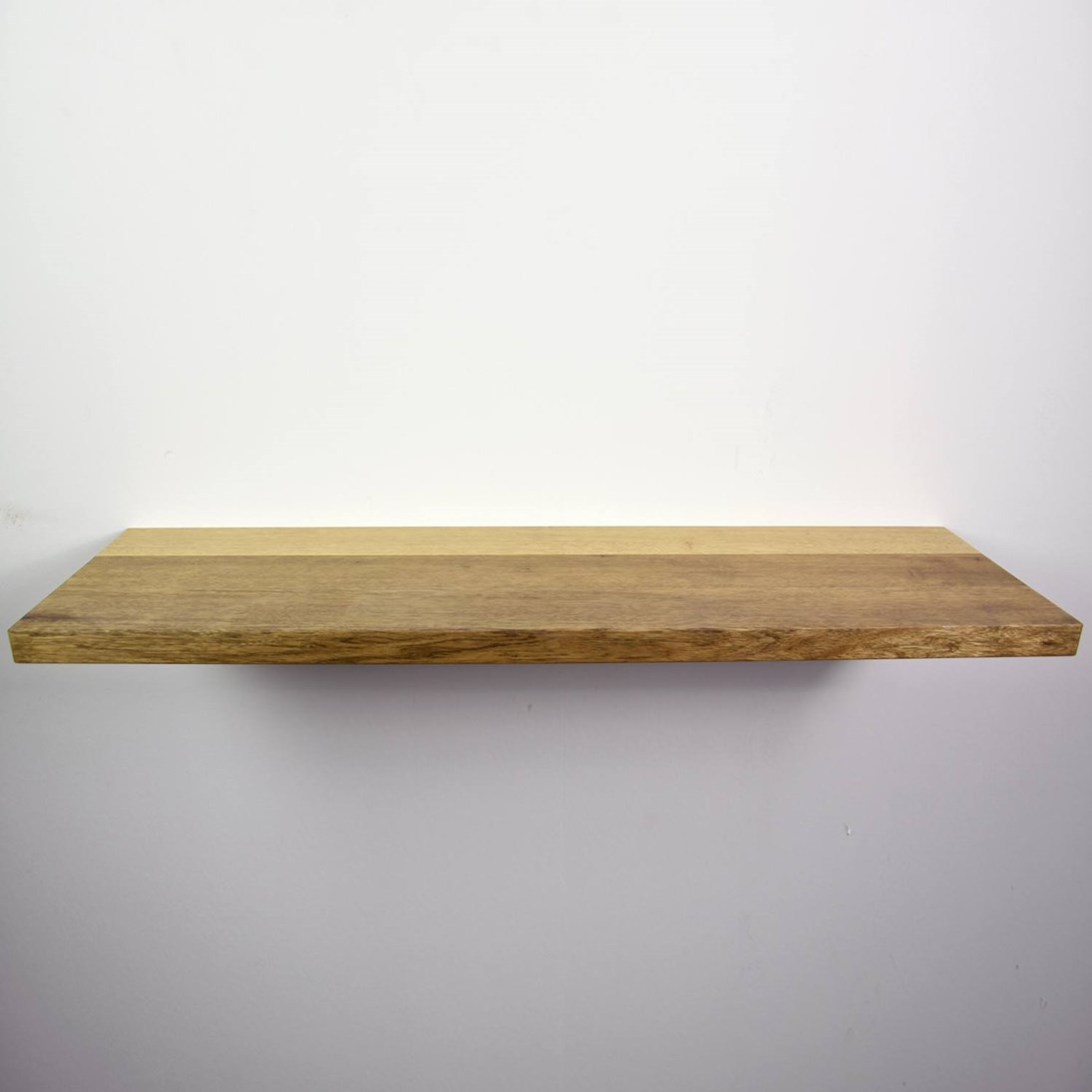 Zwevende mansonia wandplank in de maat 1140x338x40mm, behandeld met lak.