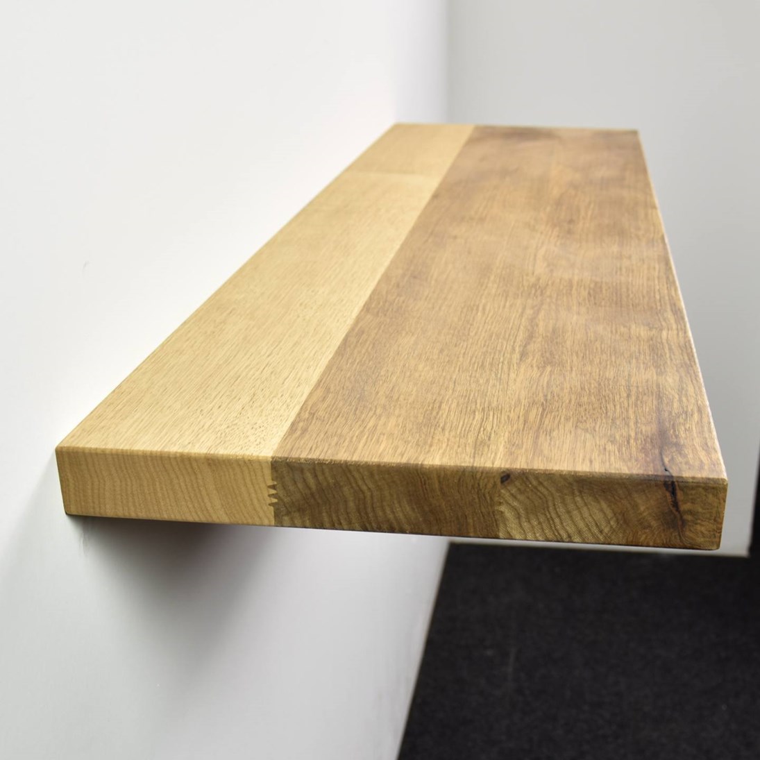 Zwevende mansonia wandplank in de maat 1140x338x40mm, behandeld met lak.